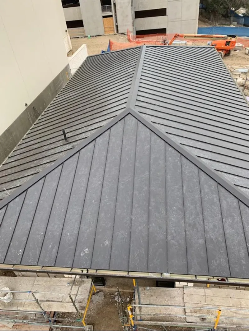 Commercial metal roof construction with crane equipment in Ponca City